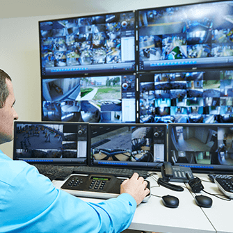 man monitoring security cameras