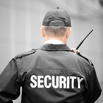 man wearing a jacket that says SECURITY while speaking to a walkie talkie