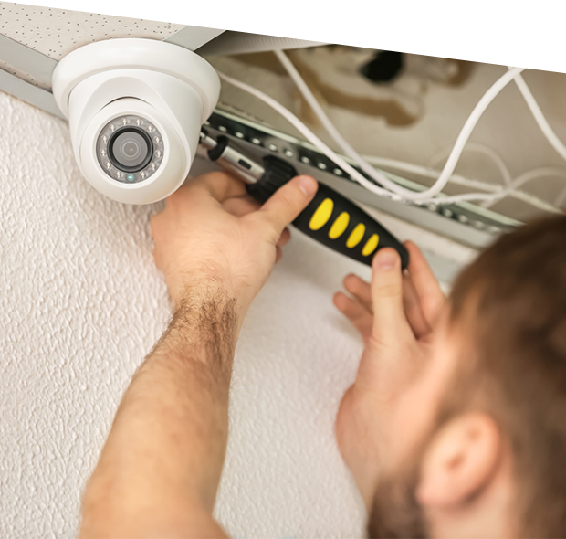 Electrician installing security camera indoors