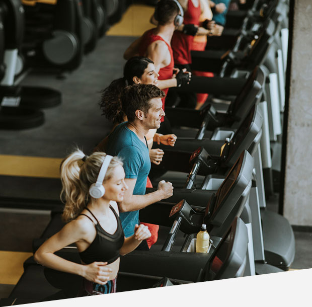 Top view at group of young people running on treadmill